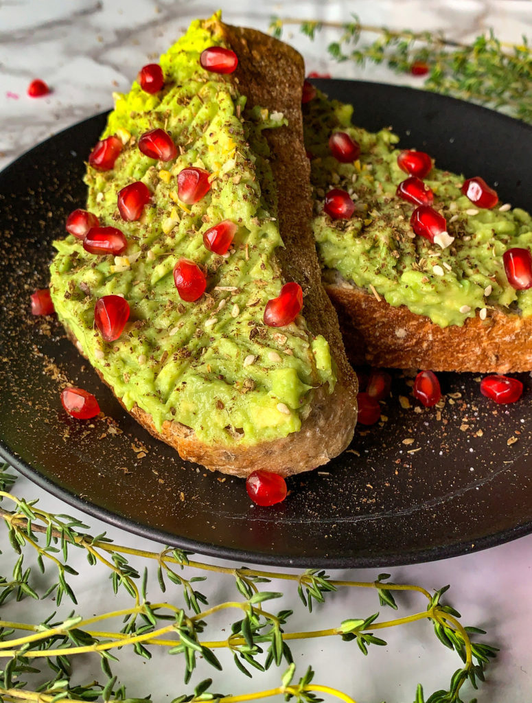 avocado toast with pomegranate and za'atar side view