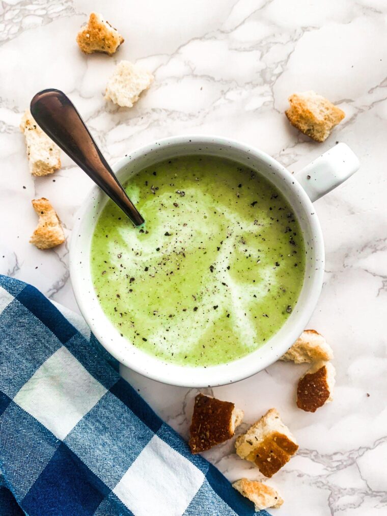 Cream of Broccoli soup in a bowl with natural light and scattered croutons.